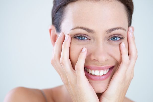 Beauty portrait of a woman laughing after receiving microcurrent facials.